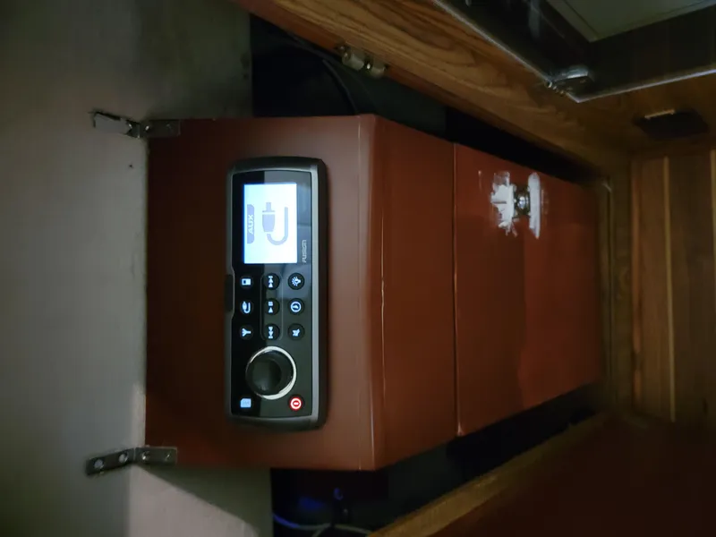 Slide: The Image of Control panel inside 1983 Bertram 33 Flybridge Cruiser, featuring modern interface and wooden cabinetry. - 23