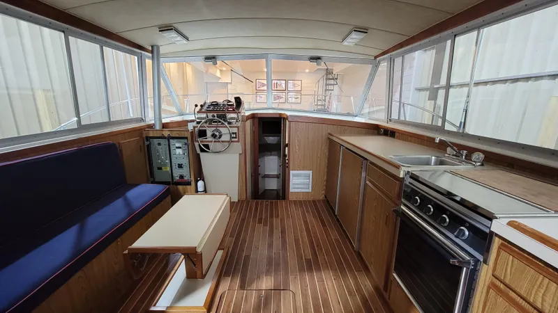 Slide: The Image of Interior of 1983 Bertram 33 Flybridge Cruiser with helm, seating, and kitchen area. - 24