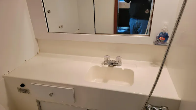 Slide: The Image of 1983 Bertram 33 Flybridge Cruiser bathroom sink with mirror and soap dispenser. - 30