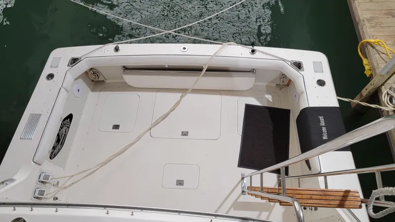 Slide: The Image of 1983 Bertram 33 Flybridge Cruiser stern view with clean deck and docked at marina. - 8