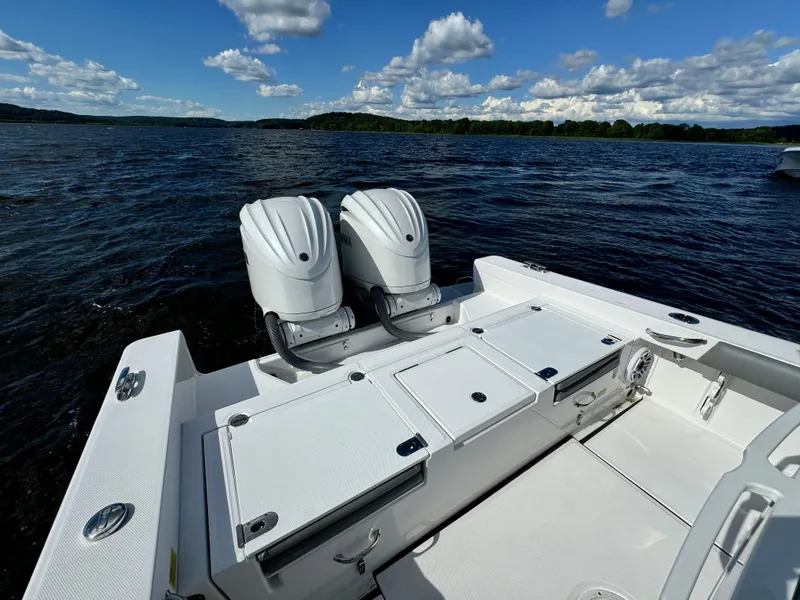 Slide: The Image of 2024 Everglades 273 Center Console boat with twin engines on a lake. - 10