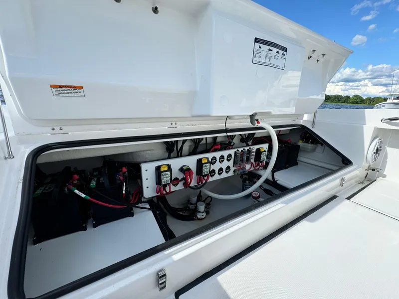 Slide: The Image of Electrical compartment of 2024 Everglades 273 Center Console boat under blue sky. - 11