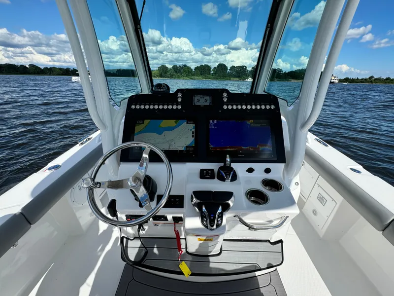 Slide: The Image of 2024 Everglades 273 Center Console boat helm with dual displays on a sunny day. - 13