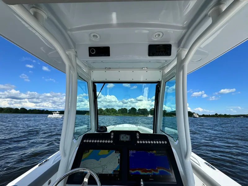 Slide: The Image of 2024 Everglades 273 Center Console boat dashboard with navigation screens on open water. - 14