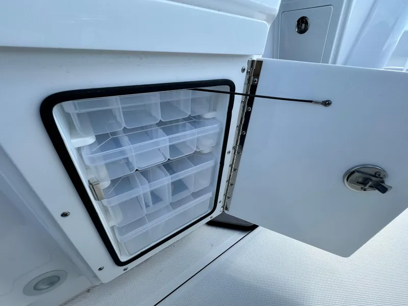 Slide: The Image of 2024 Everglades 273 Center Console storage compartment with organized plastic containers. - 15