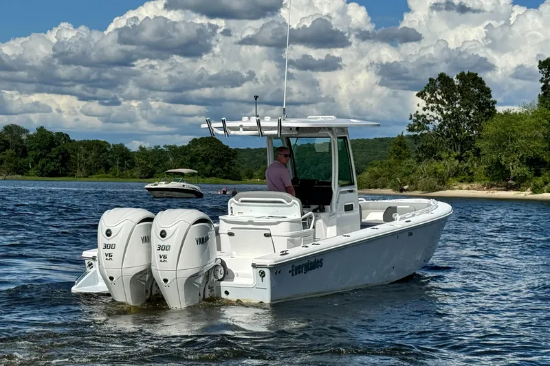 Slide: The Image of 2024 Everglades 273 Center Console boat with twin Yamaha 300 engines on a lake. - 3