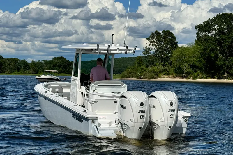 Slide: The Image of 2024 Everglades 273 Center Console boat with twin Yamaha 300 V6 engines on a lake. - 5
