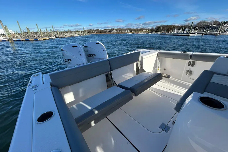 Slide: The Image of 2024 Everglades 335 Center Console boat with dual XTO engines, docked in a marina. - 16