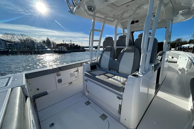 Slide: The Image of 2024 Everglades 335 Center Console boat interior with seating, under sunny sky. - 17