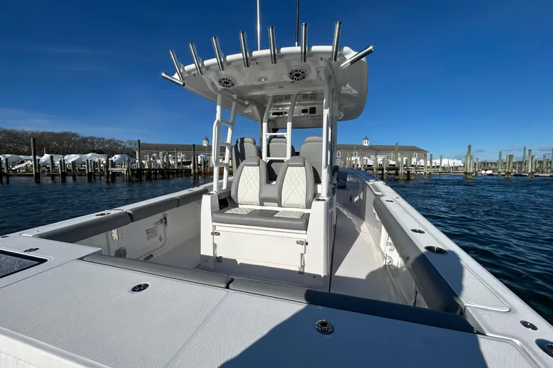 Slide: The Image of 2024 Everglades 335 Center Console boat docked, showcasing sleek design and spacious seating. - 19