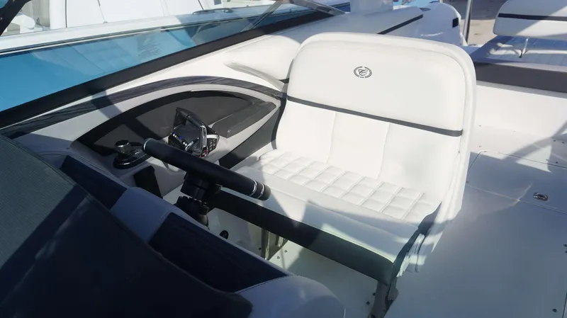 Slide: The Image of 2024 Cobalt 30 SC boat cockpit with white seating and steering wheel. - 8