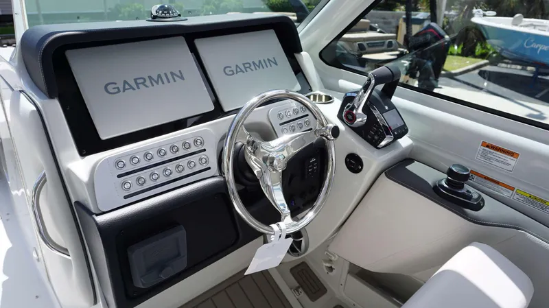 Slide: The Image of 2024 Crownline 280 DC boat dashboard with Garmin navigation screens and modern controls. - 11