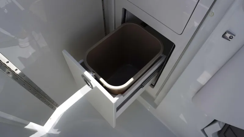 Slide: The Image of Built-in trash bin in the 2024 Crownline 280 DC boat. - 18