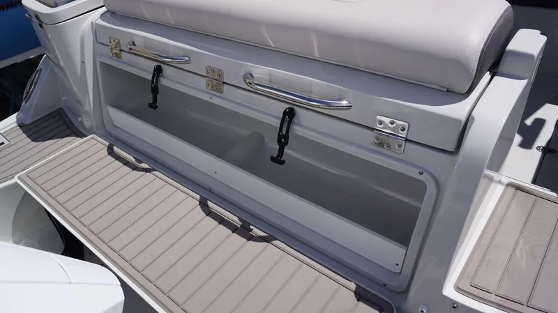 Slide: The Image of 2024 Crownline 280 DC boat storage compartment with cushioned seating and stainless steel handles. - 22