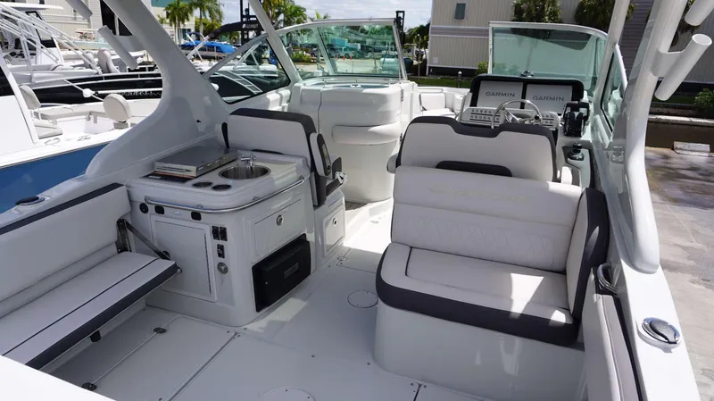 Slide: The Image of 2024 Crownline 280 DC boat interior with seating, sink, and Garmin navigation system. - 25
