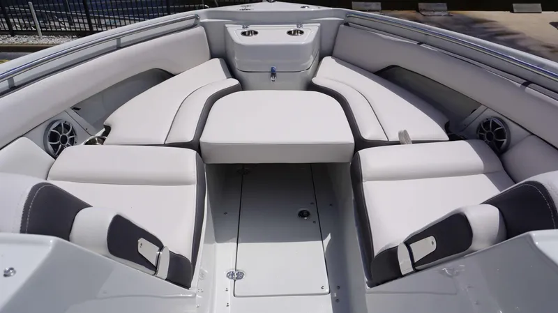 Slide: The Image of 2024 Crownline 280 DC boat interior with white cushioned seating and cup holders. - 26