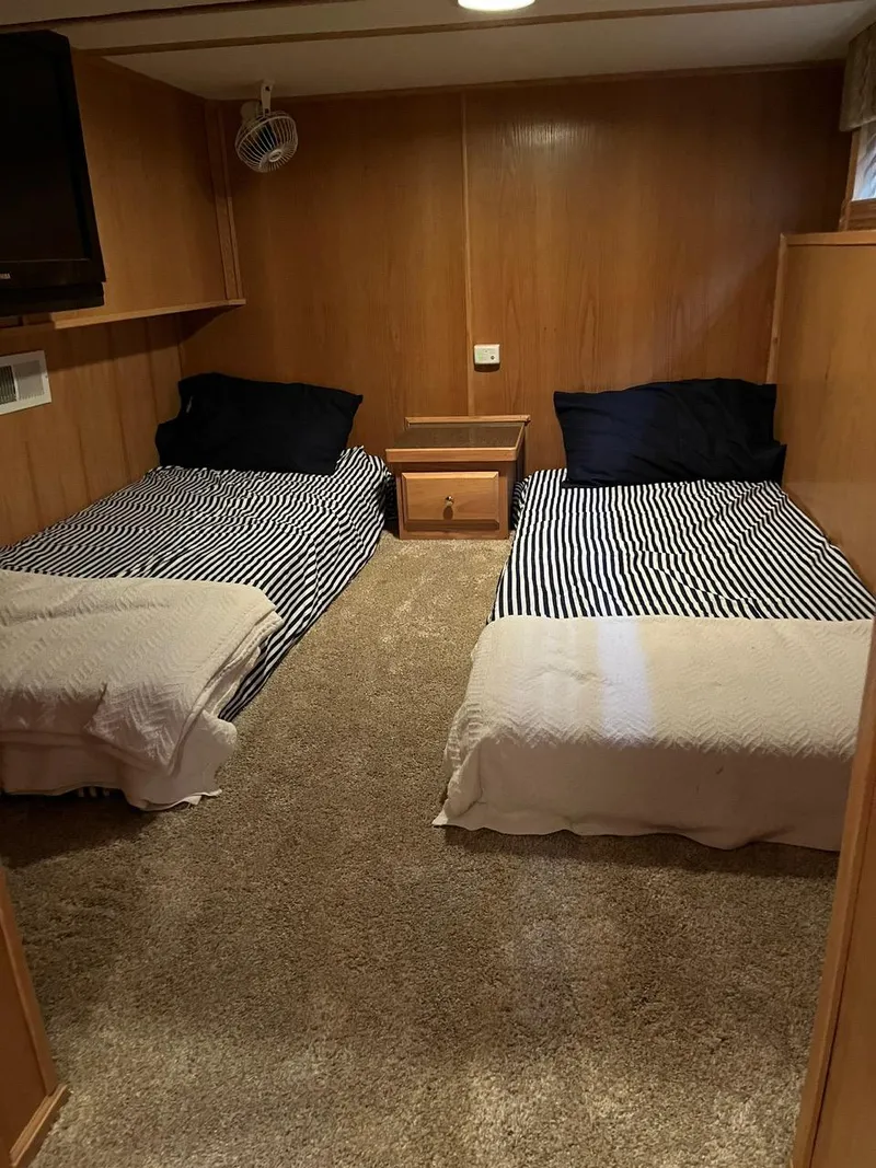 Slide: The Image of 2003 Lakeview Houseboat bedroom with twin beds and wood paneling. - 16