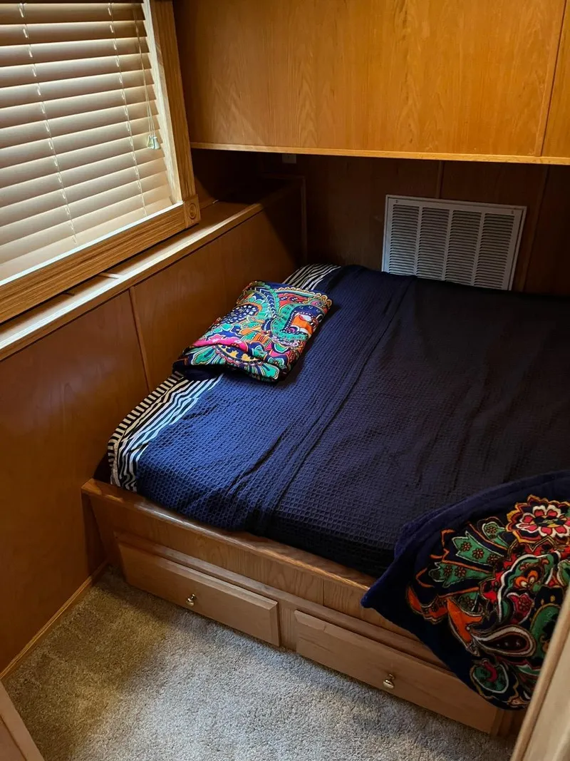 Slide: The Image of Cozy bedroom in a 2003 Lakeview houseboat with wooden interior and colorful bedding. - 17
