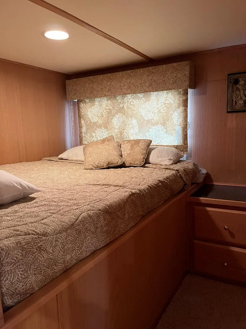 Slide: The Image of Cozy bedroom in a 2003 Lakeview Houseboat with patterned bedding and wooden interior. - 20