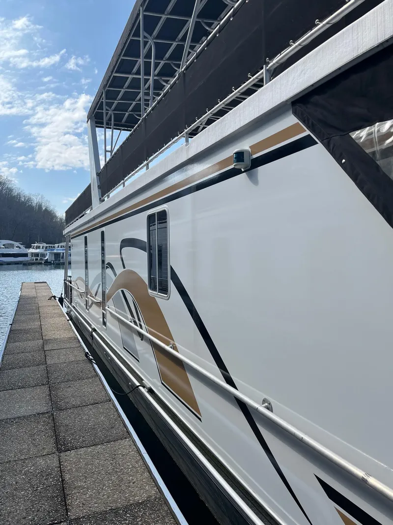 Slide: The Image of 2003 Lakeview Houseboat docked at a marina on a sunny day. - 4