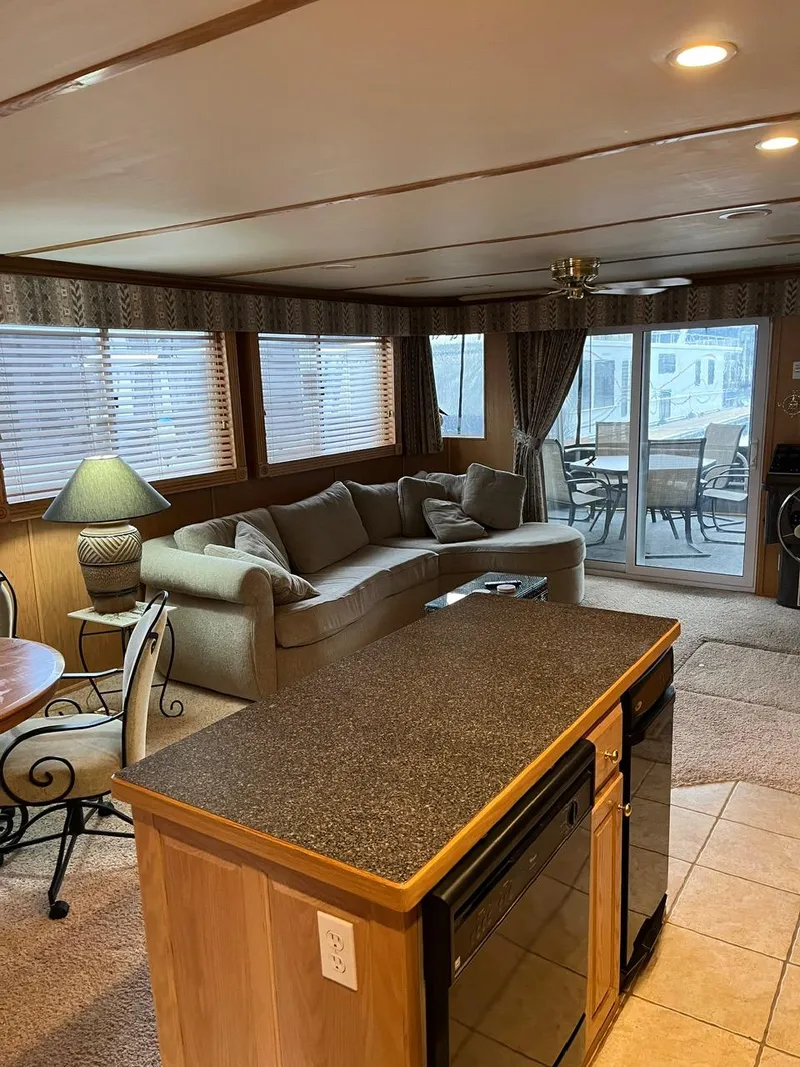 Slide: The Image of Interior of a 2003 Lakeview Houseboat with cozy living area and kitchen island. - 9