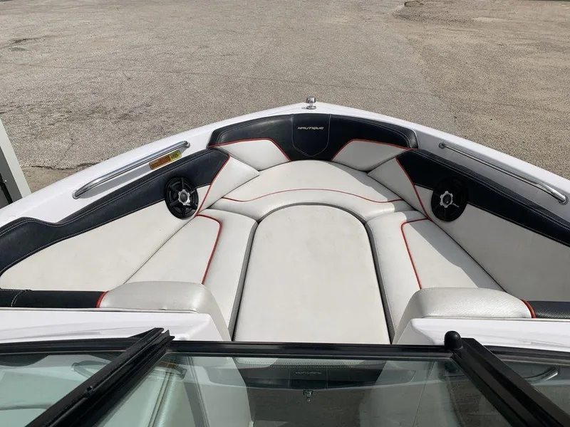 Slide: The Image of 2012 Nautique 230 boat interior with white and black seating, red accents. - 3