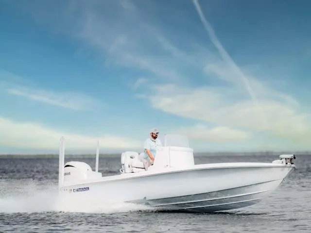 Slide: The Image of 2024 Contender 26BAY boat cruising on open water under a clear blue sky. - 1