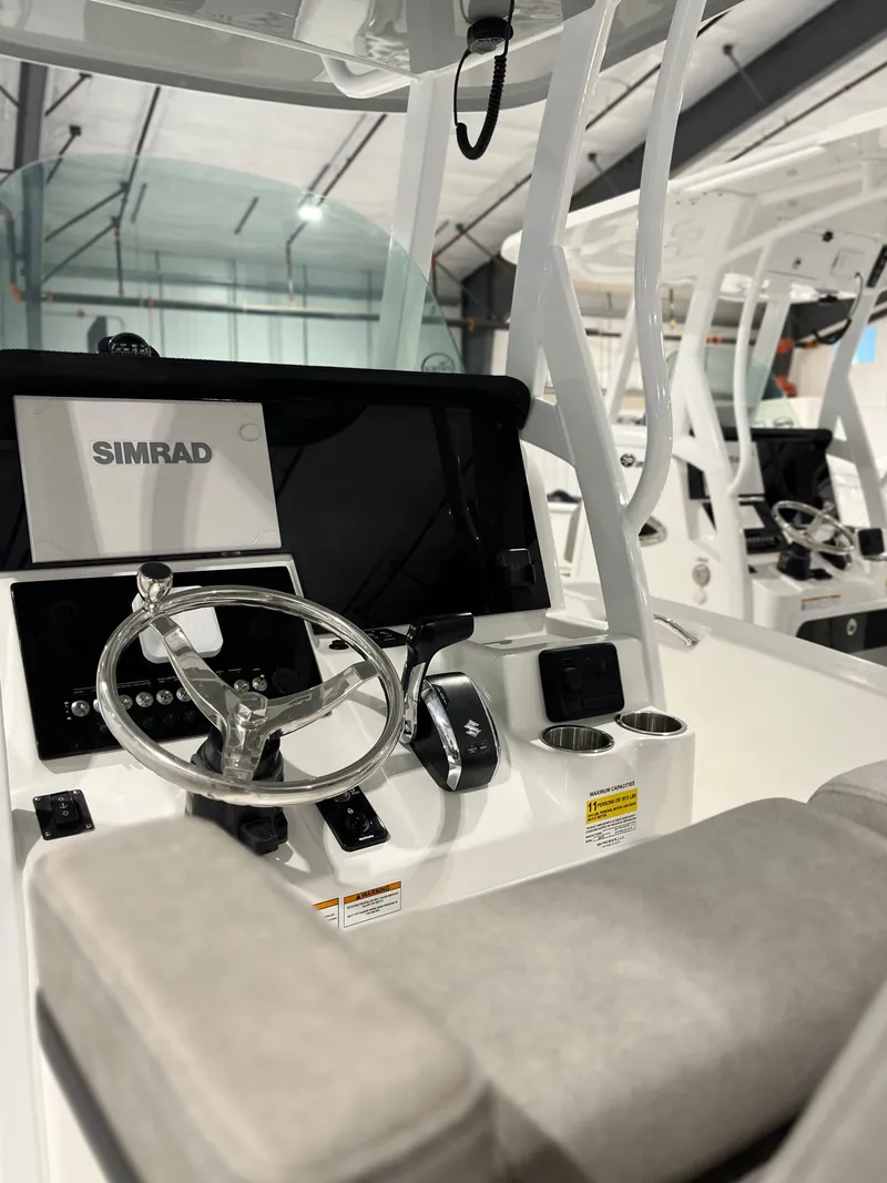 Slide: The Image of 2024 Sea Pro 242 DLX boat console with Simrad electronics and steering wheel. - 1