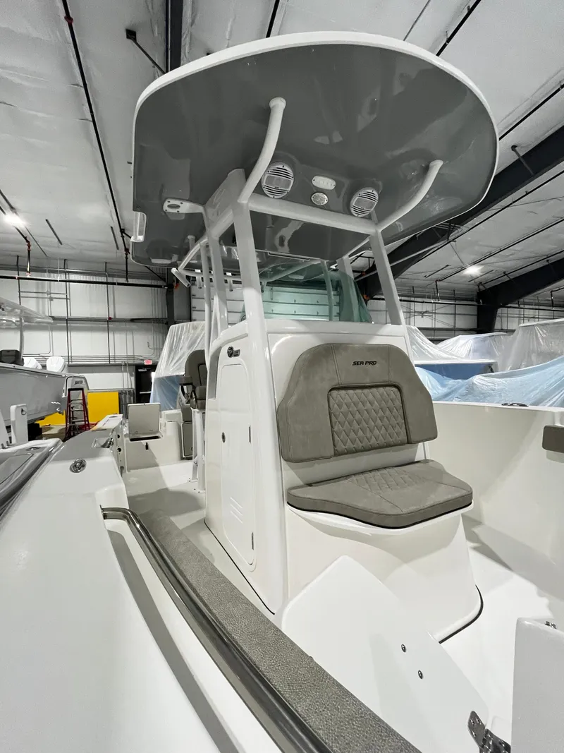 Slide: The Image of 2024 Sea Pro 242 DLX center console boat in a storage facility. - 11