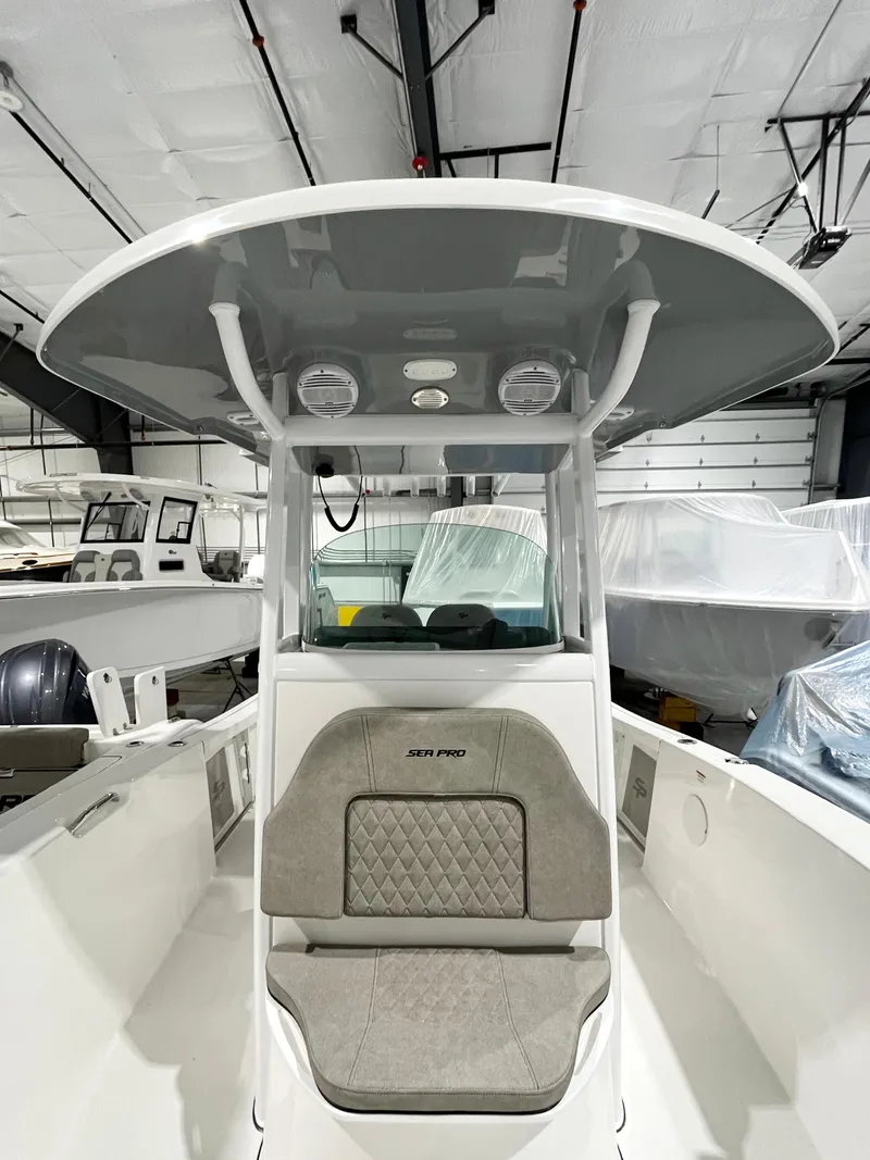Slide: The Image of 2024 Sea Pro 242 DLX center console boat in a showroom. - 13