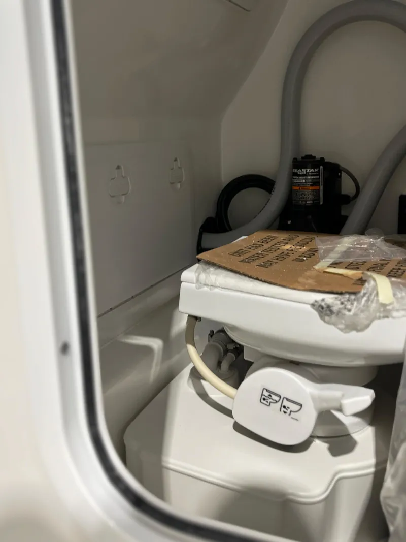 Slide: The Image of 2024 Sea Pro 242 DLX boat interior with marine toilet and plumbing. - 14