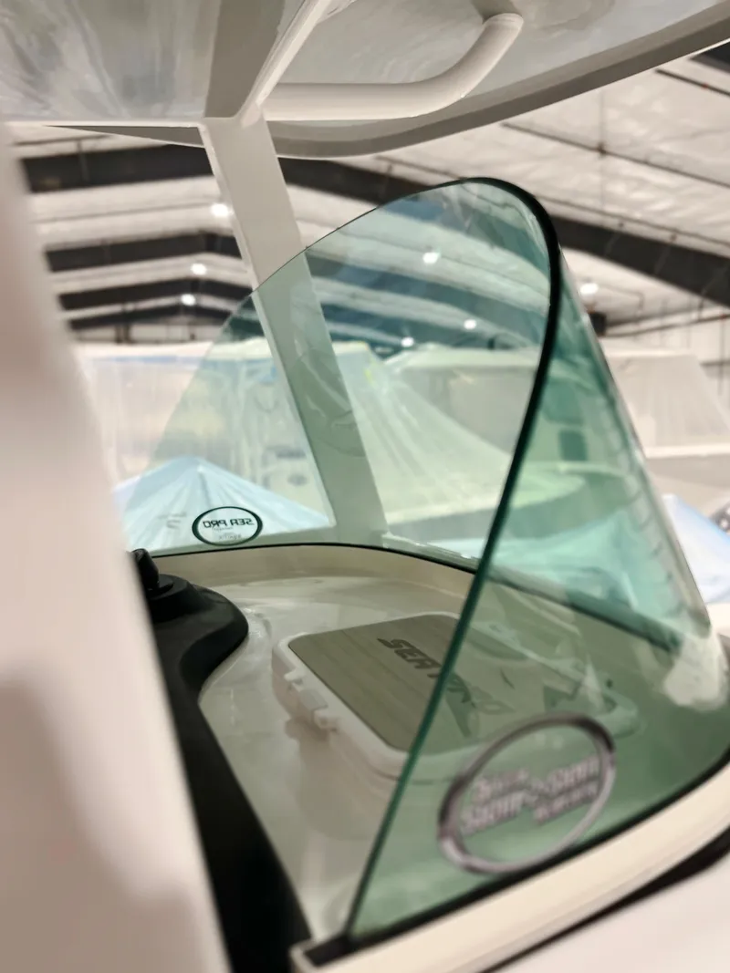 Slide: The Image of 2024 Sea Pro 242 DLX boat windshield and console in a showroom. - 4