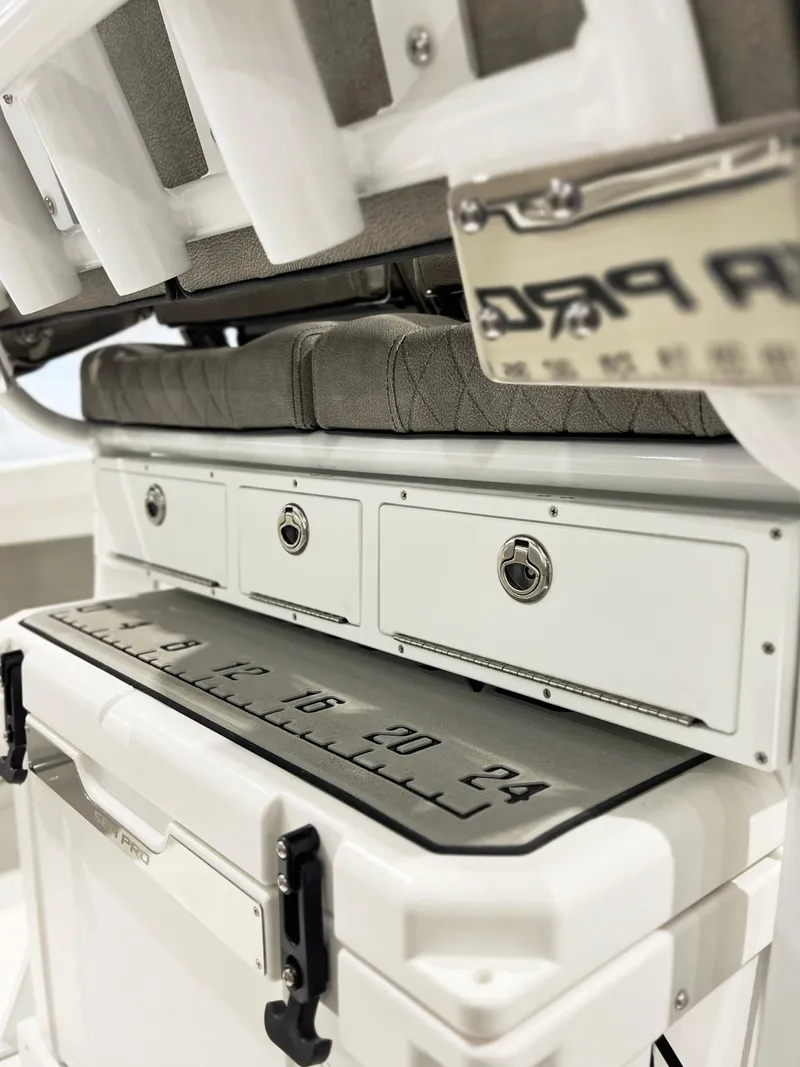 Slide: The Image of 2024 Sea Pro 242 DLX boat storage compartments and cooler with measuring scale. - 9