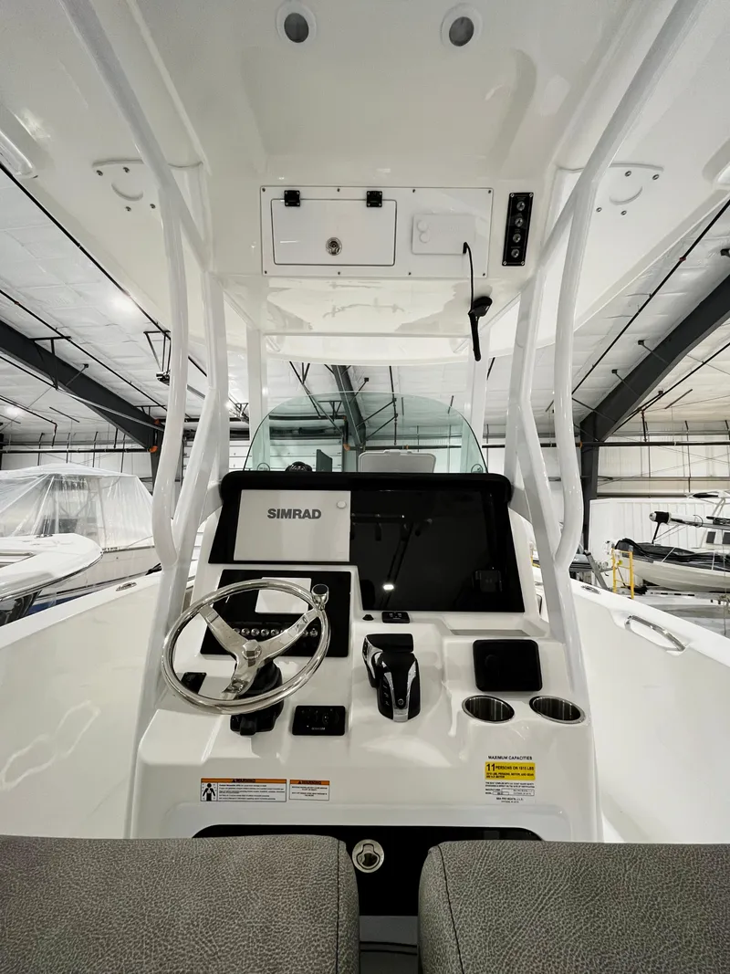 Slide: The Image of 2024 Sea Pro 242 DLX boat console with Simrad electronics in a showroom. - 2