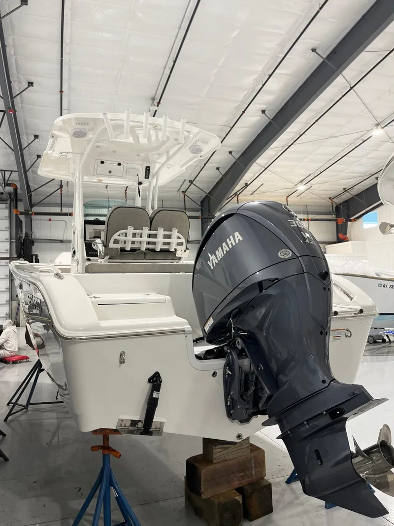 Slide: The Image of 2024 Sea Pro 242 DLX boat with Yamaha outboard motor in a storage facility. - 6