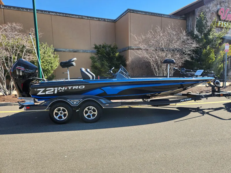Slide: The Image of 2024 Nitro Z21 XL Pro bass boat on a trailer, parked outdoors. - 0