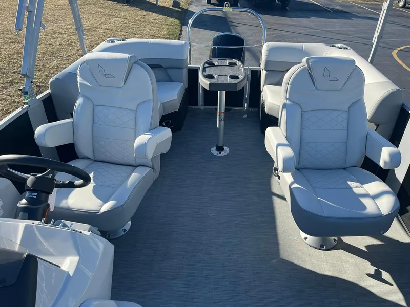Slide: The Image of 2024 Lowe SS 210 WT pontoon boat interior with plush seating and steering console. - 10