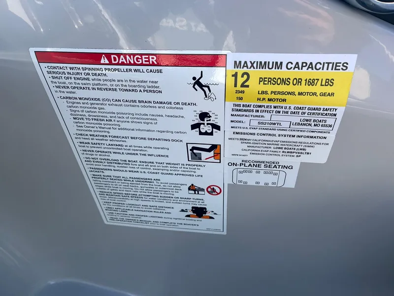 Slide: The Image of Warning and capacity labels on 2024 Lowe SS 210 WT boat, 12-person limit. - 20