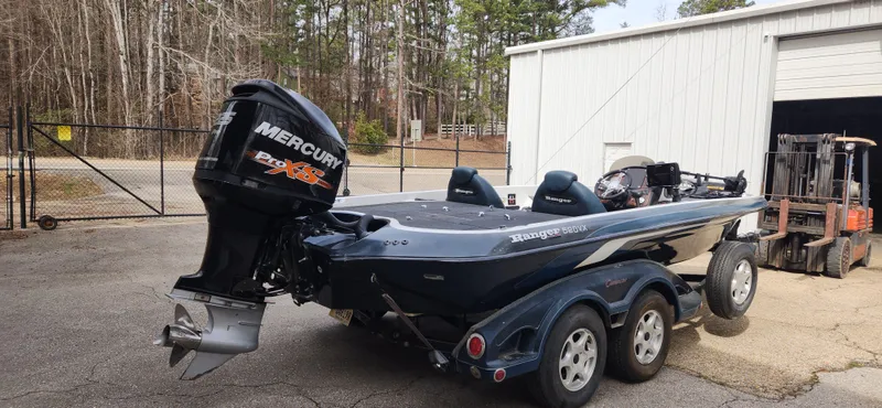 Slide: The Image of 2005 Ranger 520 VX boat with Mercury outboard motor parked outside a garage. - 3