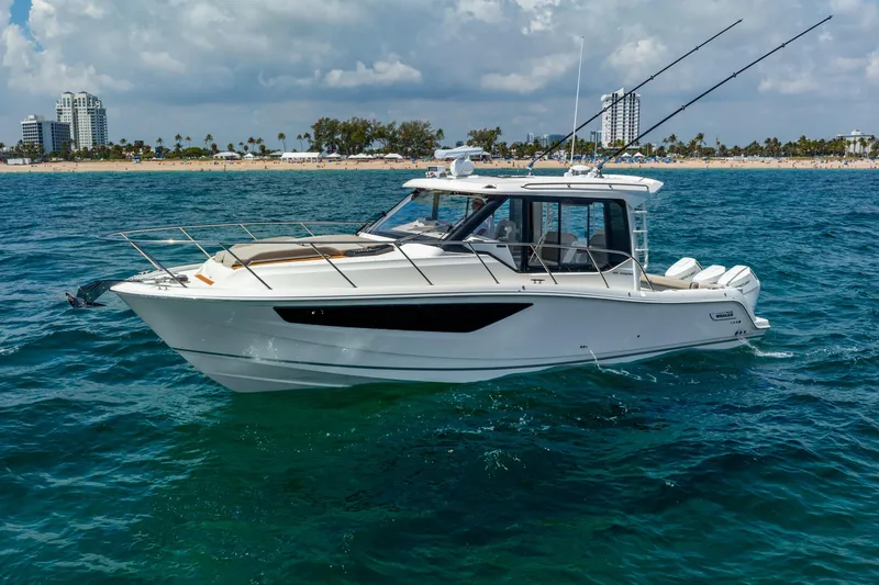 The Image of 2025 Boston Whaler 365 Conquest boat cruising on ocean near sandy beach. - 0