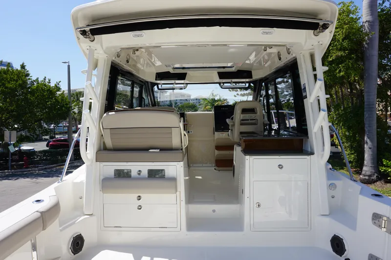 Slide: The Image of 2025 Boston Whaler 365 Conquest interior, featuring seating and storage, docked outdoors. - 15
