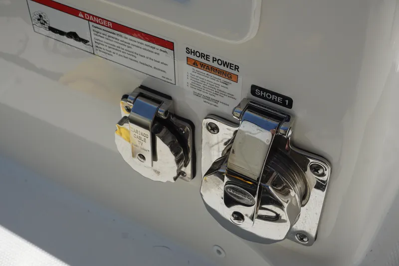 Slide: The Image of 2025 Boston Whaler 365 Conquest shore power connections with safety warnings. - 20