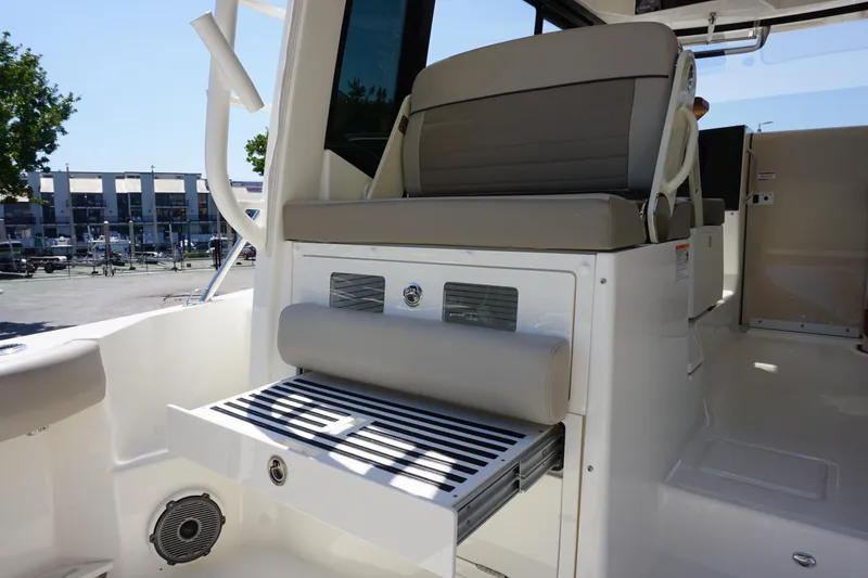 Slide: The Image of 2025 Boston Whaler 365 Conquest interior seating area with foldable bench and speaker. - 25