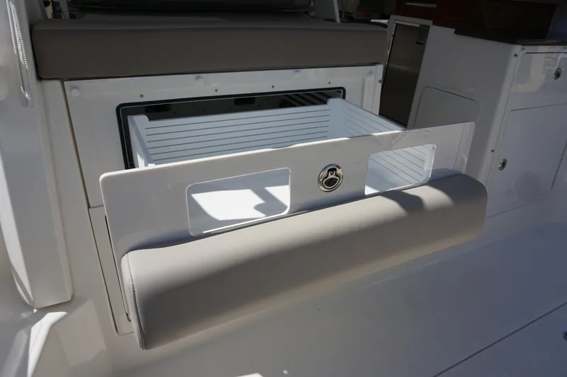 Slide: The Image of Boston Whaler 365 Conquest 2025 boat storage compartment with cushioned seating. - 26