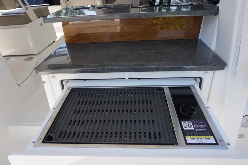 Slide: The Image of 2025 Boston Whaler 365 Conquest boat interior with built-in grill and countertop. - 29