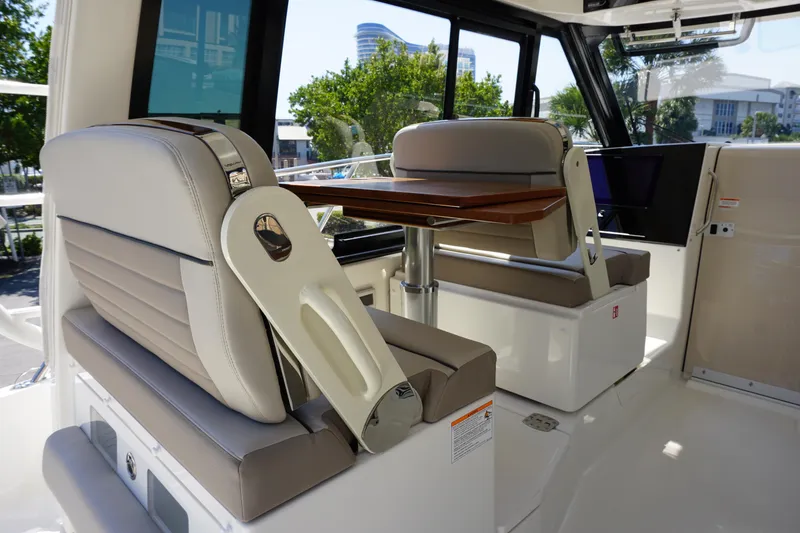 Slide: The Image of 2025 Boston Whaler 365 Conquest interior with plush seating and wooden table. - 35