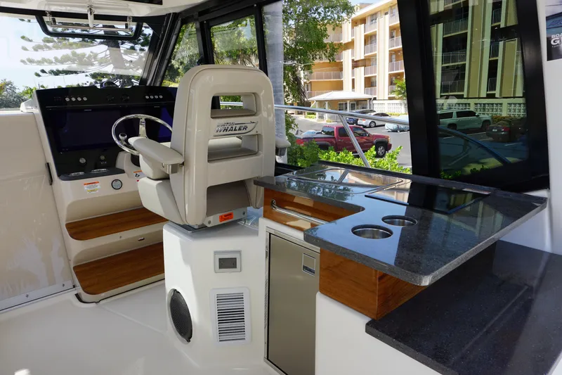 Slide: The Image of Interior of 2025 Boston Whaler 365 Conquest boat with helm and kitchenette. - 36