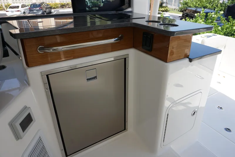 Slide: The Image of 2025 Boston Whaler 365 Conquest boat interior with sleek kitchenette and stainless steel appliances. - 37