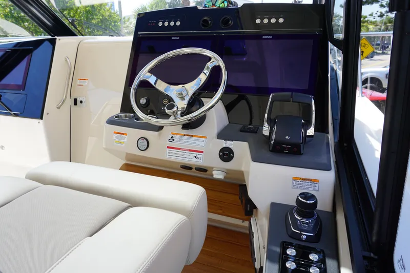 Slide: The Image of 2025 Boston Whaler 365 Conquest helm with modern controls and steering wheel. - 49