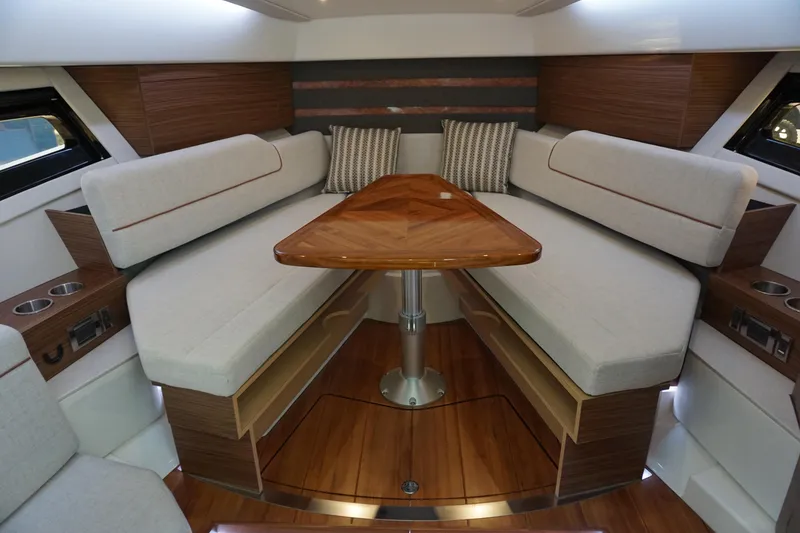 Slide: The Image of Interior of 2025 Boston Whaler 365 Conquest, featuring elegant seating and wooden table. - 54